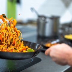 Nudeln werden in der Pfanne geschwenkt.